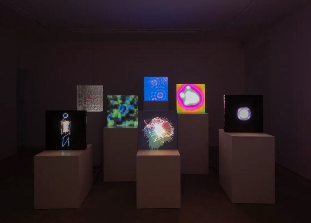 individual LED panels arranged on plinths displaying NFT art from Botto