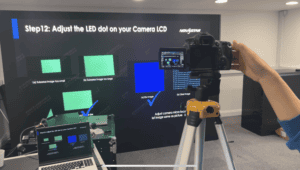 Engineer setting up a camera on a tripod to measure an LED wall during calibration