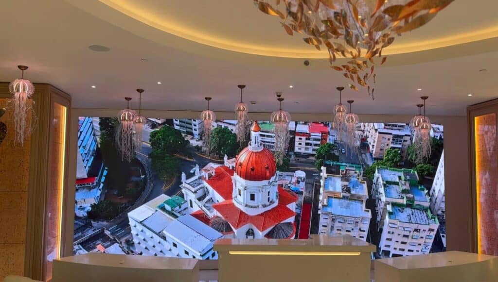 Hotel Londres lobby LED video wall showing aerial view of a Venezuelan cathedral with red dome