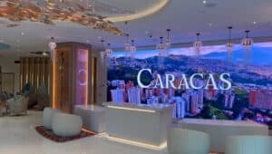 Full lobby view of Hotel Londres with LED video wall displaying Caracas cityscape and gold leaf ceiling