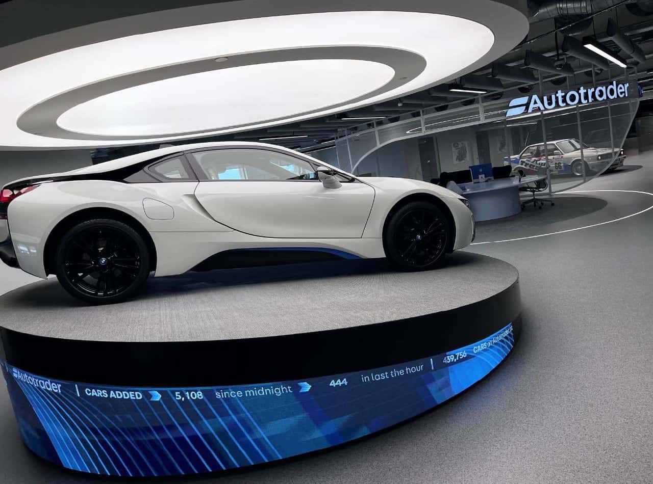 AutoTrader Manchester HQ – P1.86mm LED plinth wrapping the car turntable with live data halo ticker suspended above a BMW i8