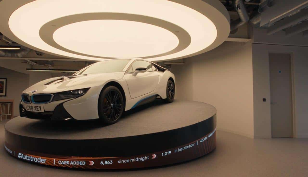 AutoTrader Manchester HQ — P1.86mm flexible LED plinth wrapping the car turntable beneath the BMW i8, with live cars-added counter visible