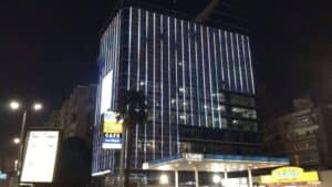Outdoor LED building facade illuminated at night in an urban setting showing light output that requires brightness management