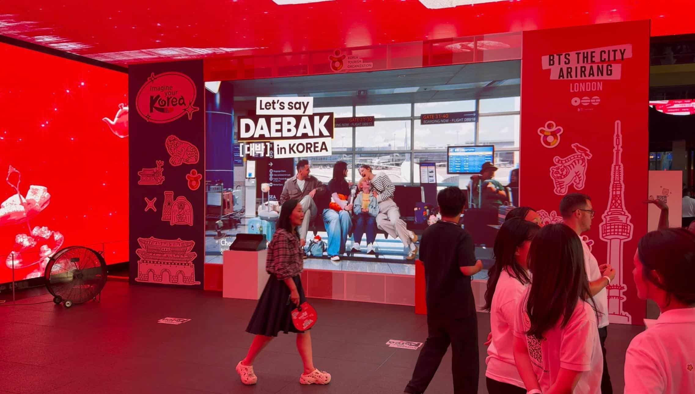 Visitors at the BTS The City Arirang London activation inside Outernet London, with the Korea Tourism Organization campaign playing on the Dynamo LED wall