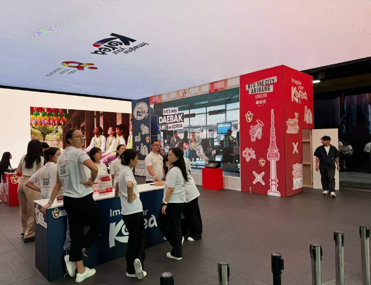 Wide view of the Imagine your Korea activation at Outernet London showing the LED wall, printed timber stand structure and visitor welcome desk
