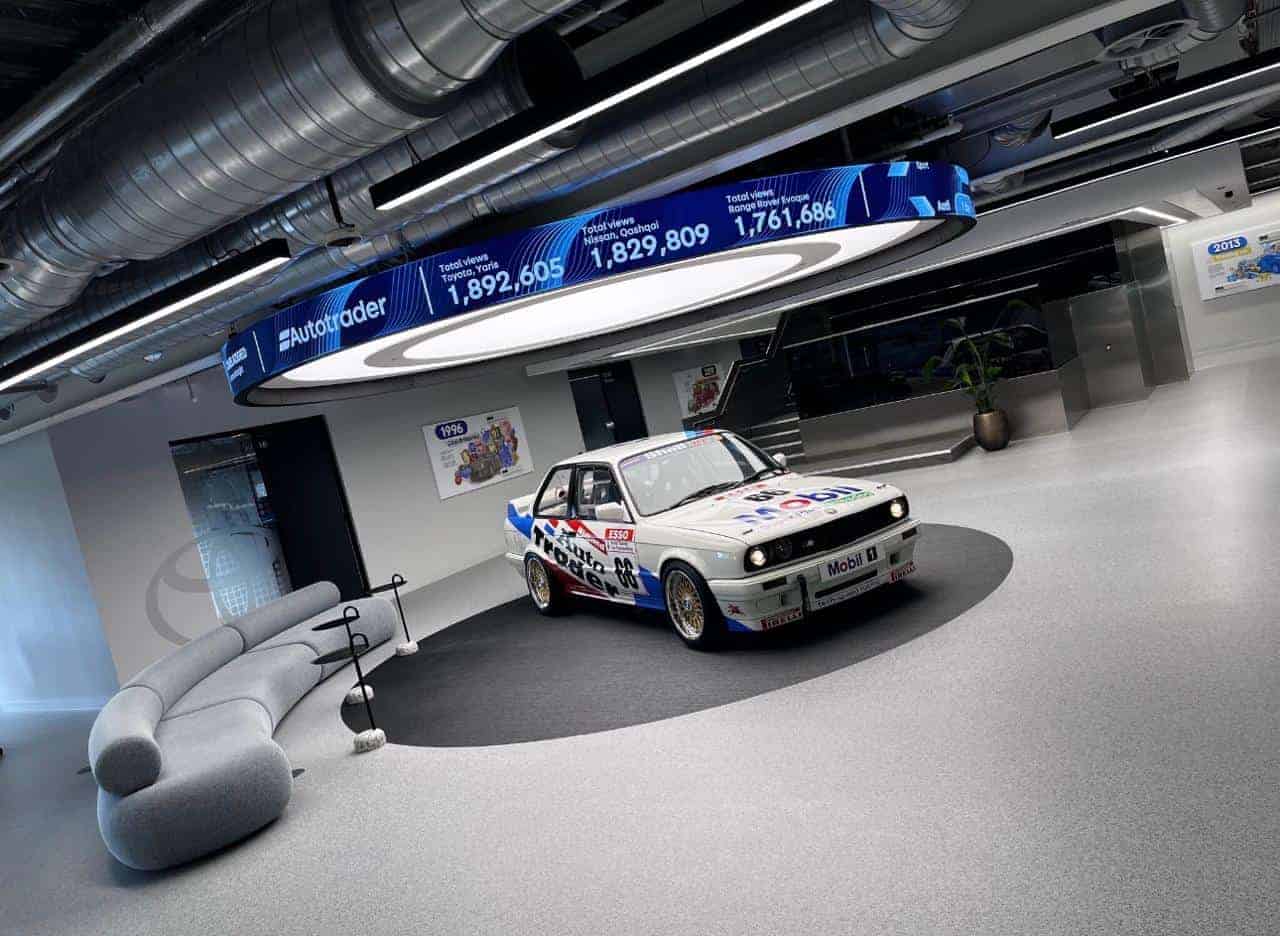 Suspended halo LED ticker carrying live platform data at Auto Trader Manchester HQ