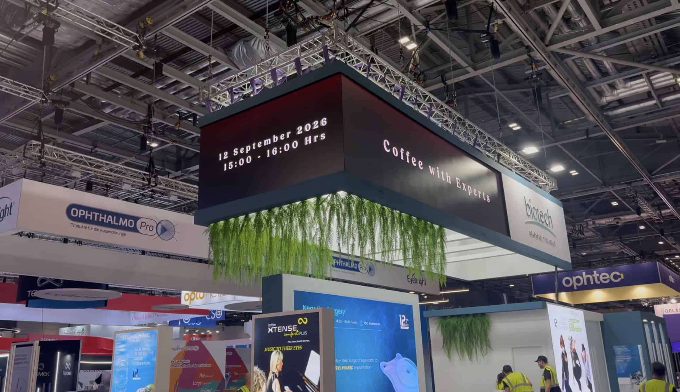 Wide view of the U-shaped overhead LED banner hung from truss above the Biotech stand at ESCRS 2026, ExCeL London
