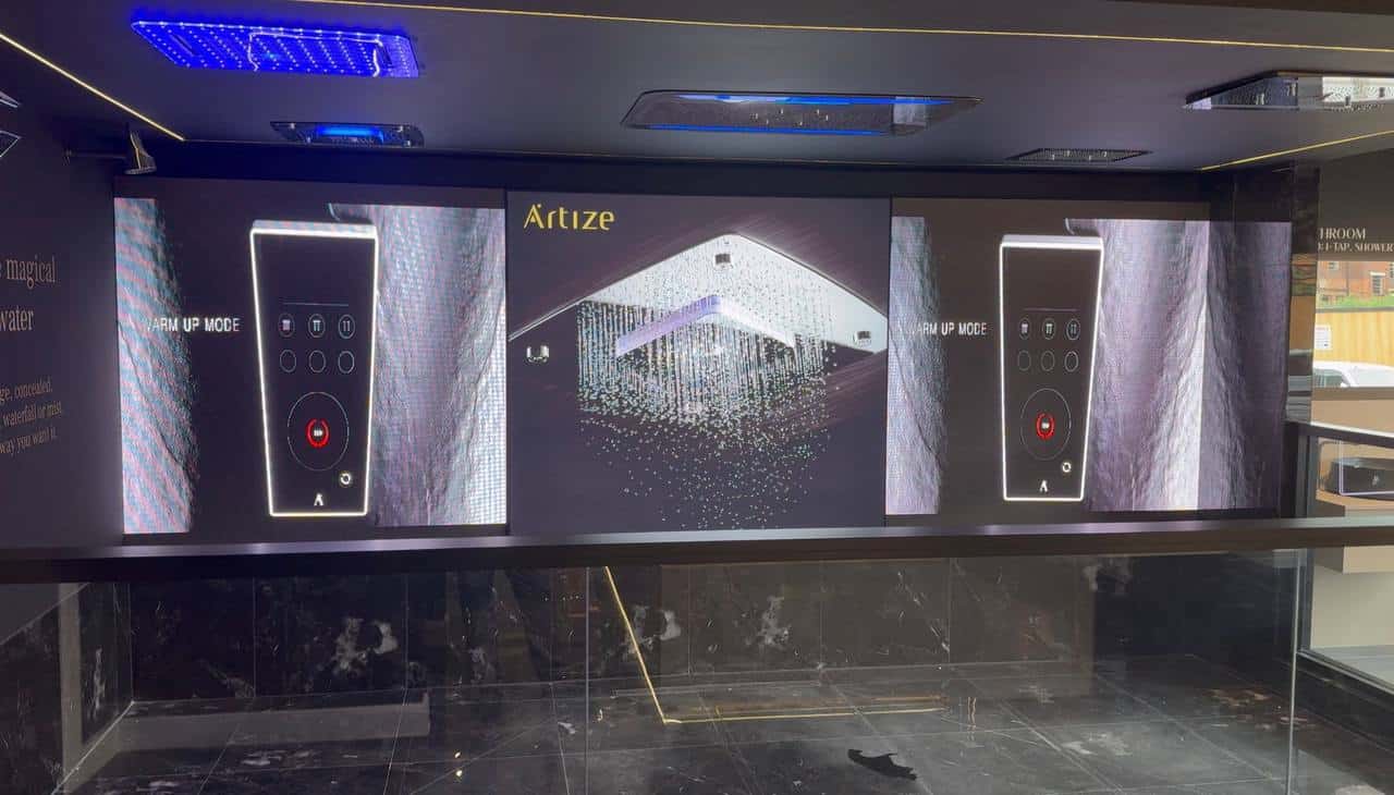Content: room sets, configurators and campaigns โ LED screens running product video on a showroom feature wall