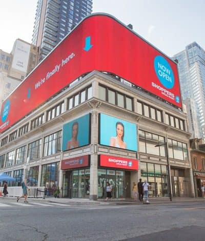 DHB Series LED cabinets wrapping a building corner above a retail frontage